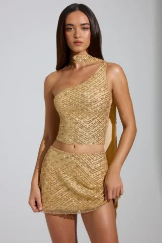 Cosette Top met asymmetrische sjaaldetails en versieringen in goud