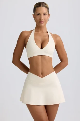 Geborstelde jersey mini-skort met gekruiste banden in ivoormelange