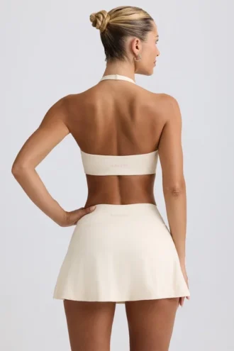 Geborstelde jersey mini-skort met gekruiste banden in ivoormelange