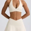 Geborstelde jersey mini-skort met gekruiste banden in ivoormelange