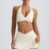 Geborstelde jersey mini-skort met gekruiste banden in ivoormelange