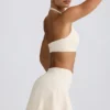 Geborstelde jersey mini-skort met gekruiste banden in ivoormelange