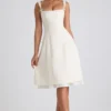 Isadora midi-jurk met strikdetail en plooien in ivoorkleur