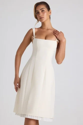 Isadora midi-jurk met strikdetail en plooien in ivoorkleur