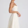 Isadora midi-jurk met strikdetail en plooien in ivoorkleur