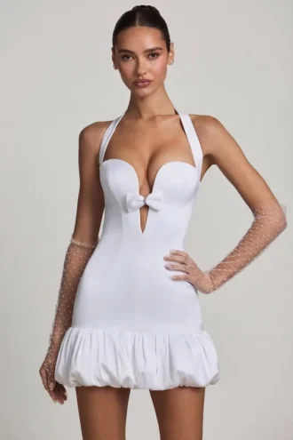 Millie minijurk met strikdetail, halternek en bolle zoom in wit