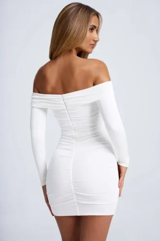 Saffron minijurk met hardware-details, off-shoulder en uitsnijdingen in wit